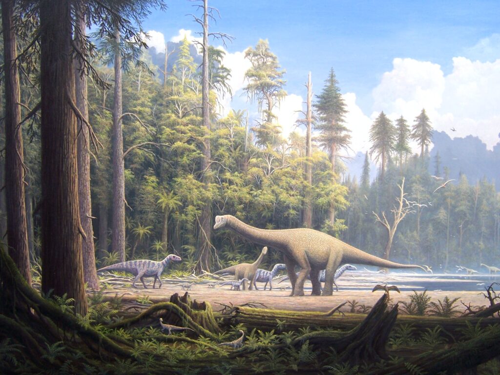 Dinosaurs roam a lush prehistoric forest, with tall conifer trees and a serene lake under a blue sky. The scene captures a tranquil, ancient era.