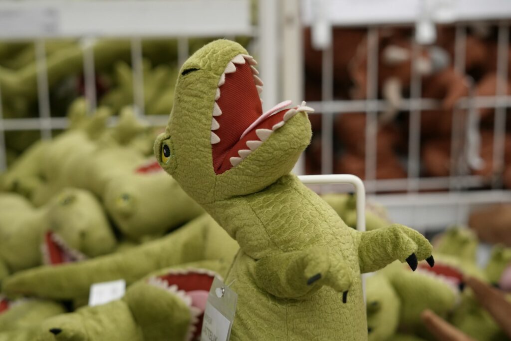 A green stuffed animal with its mouth open