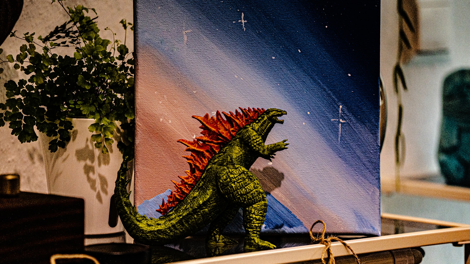 Godzilla figure in front of a painting.
