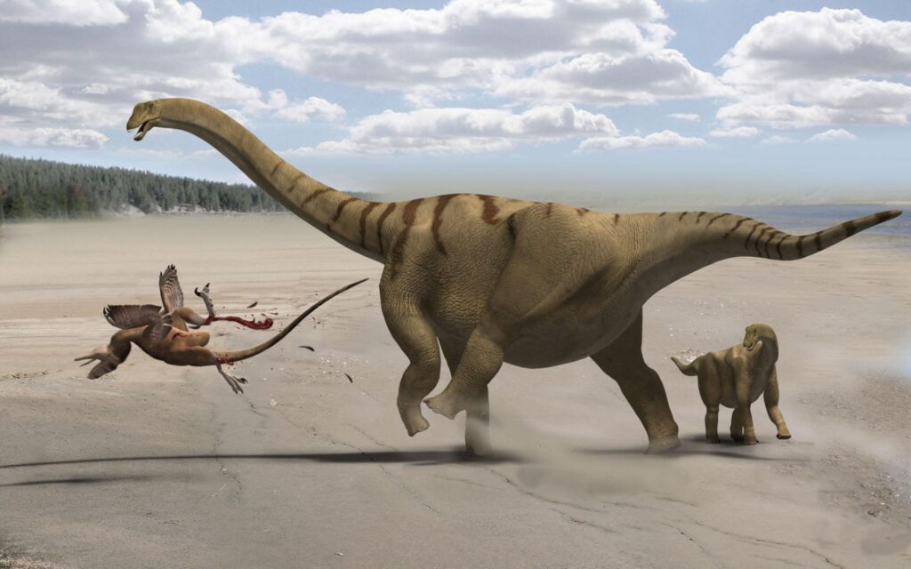 A long-necked dinosaur defends its calf from an attacking raptor on a sandy terrain. The scene depicts movement and tension under a sky with clouds.