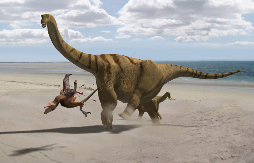 Large sauropod dinosaur on a sandy beach, stepping on a smaller, feathered dinosaur. The scene is dynamic under a partly cloudy sky.