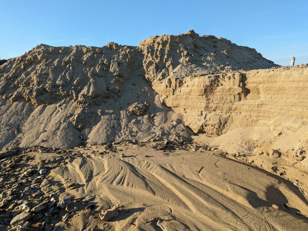 a large pile of sand sitting on top of a beach