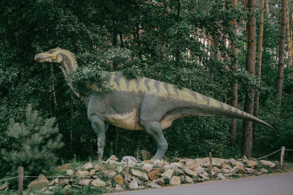 a statue of a dinosaur in the middle of a forest