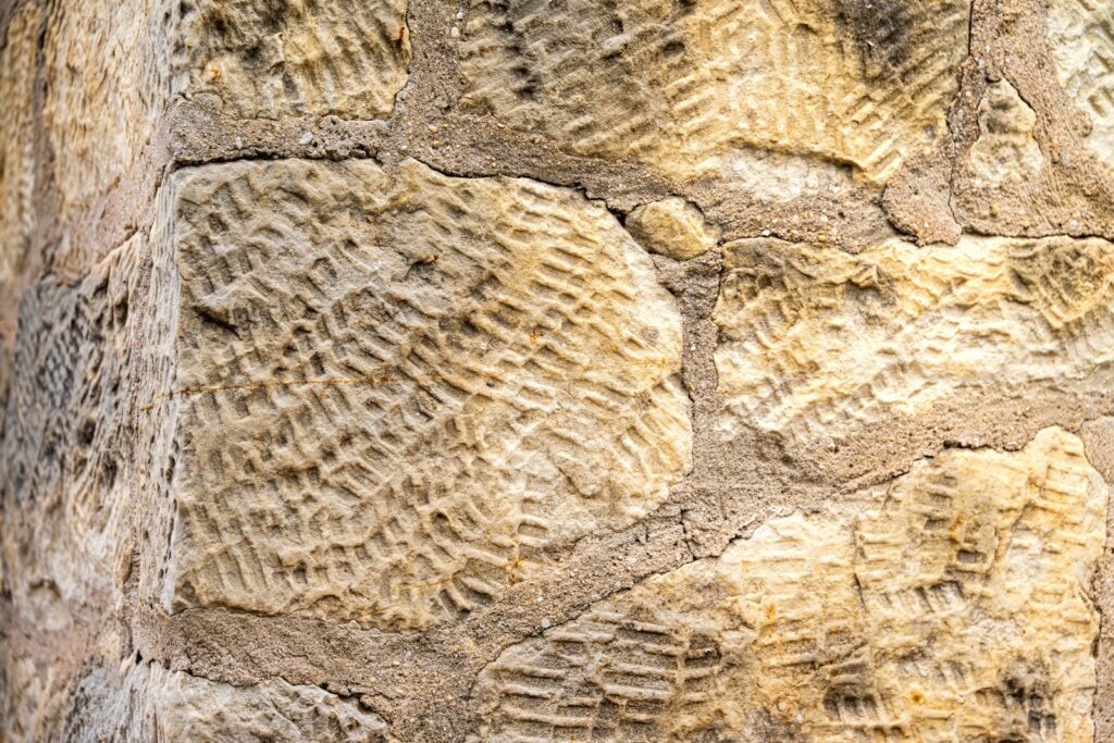 a close up of a stone wall with a clock on it