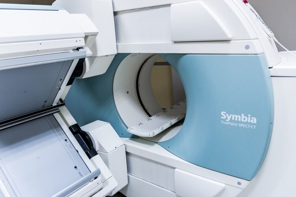 A modern CT scanning machine in a lab, positioned to analyze a fossil encased in a protective mount for internal imaging.