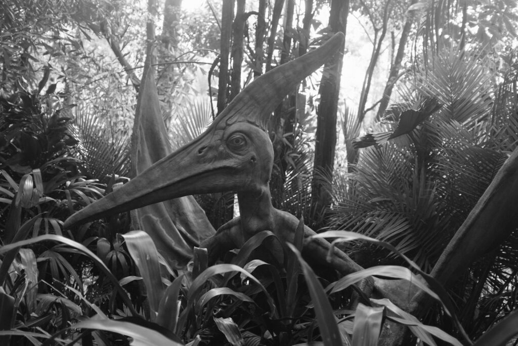 A pterodactyl statue in a jungle setting.